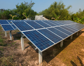 Ground-mounted solar panels in Telangana, installed in an outdoor setting, capturing sunlight for renewable energy generation surrounded by greenery.